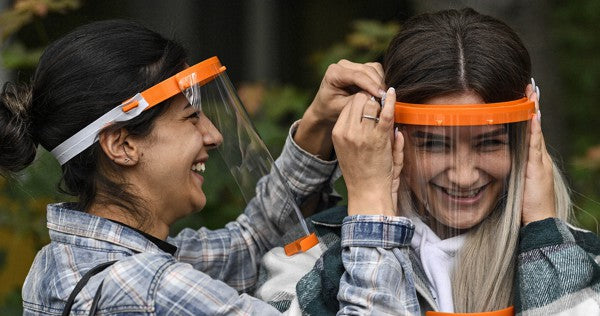 Students try out a new face shield to fight the Coronavirus pandemic at a school in Cologne, Germany